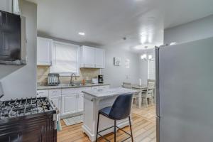 a kitchen with white cabinets and a table with a chair at Updated Detroit Vacation Rental about 9 Mi to Downtown in Detroit