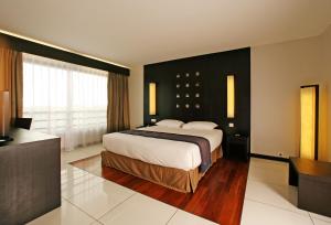 um quarto com uma cama grande e uma janela grande em Hotel Tahiti Nui em Papeete