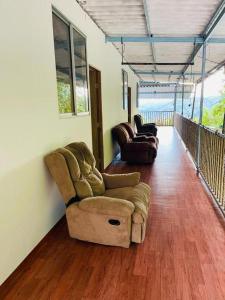 een woonkamer met 2 stoelen en een bank bij EL EDEN HABITACIONES in Manizales