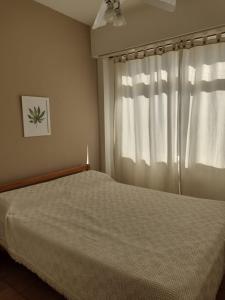 1 dormitorio con cama y ventana en Mar del Plata,Alquileres Temporarios en Mar del Plata