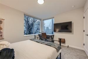 a bedroom with a bed and a desk and a tv at Wallingford Comfort BY Betterstay in Seattle