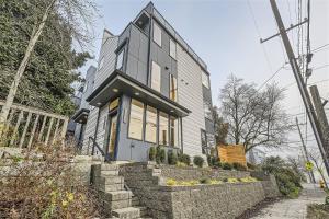 a house on a street with a stone wall at Wallingford Comfort BY Betterstay in Seattle