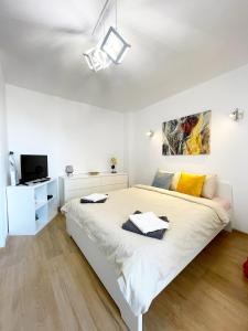 - une chambre blanche avec un grand lit et une télévision dans l'établissement Alegro Studio Apartment, à Bucarest