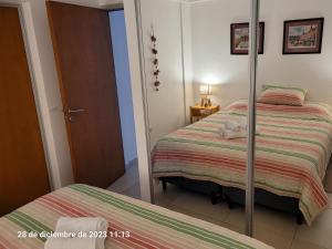 a bedroom with two beds and a mirror at Departamento centrico en Posadas in Posadas