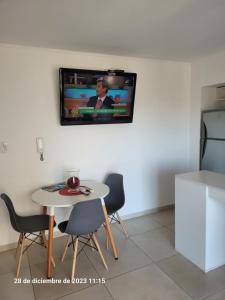 un soggiorno con tavolo e TV a parete di Departamento centrico en Posadas a Posadas