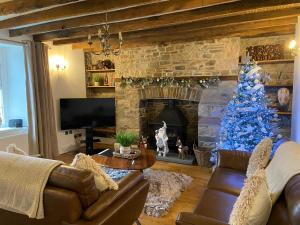 a living room with a blue christmas tree in front of a fireplace at The Farmhouse in Swansea