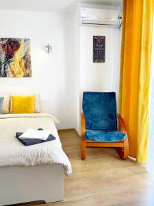 - une chambre avec une chaise bleue à côté d'un lit dans l'établissement Alegro Studio Apartment, à Bucarest