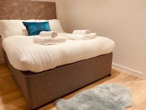 een bed met handdoeken en een blauw kussen bij Spacious 3 Bed City Apartment with Terrace in Londen