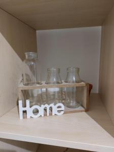 una mensola con dei barattoli di vetro con la parola "casa". di Casa Vacanze Aenaria-Ristrutturato 2024 a Ischia
