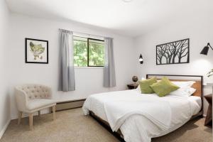 a bedroom with a bed and a chair and a window at Whidbey Gathering Place BY Betterstay in Coupeville