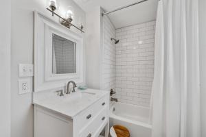 ein weißes Badezimmer mit Waschbecken und Badewanne in der Unterkunft Bon Vie in Gulf Shores + 47 Fotos