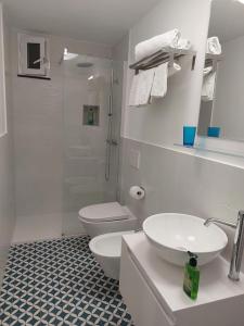 e bagno con servizi igienici, lavandino e doccia. di Casa Vacanze Aenaria-Ristrutturato 2024 a Ischia