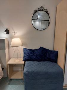 sypialnia z niebieskim łóżkiem i lustrem w obiekcie Casa Vacanze Aenaria-Ristrutturato 2024 w mieście Ischia