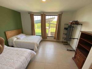 - une chambre avec 2 lits et une fenêtre dans l'établissement Villa privada con una vista espectacular!, à Aguascalientes