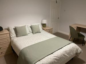 a bedroom with a large bed with a desk and a desk at Duplex Flat Bedworth Town Centre in Bedworth