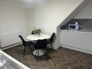 a kitchen with a table and chairs and a microwave at Duplex Flat Bedworth Town Centre in Bedworth