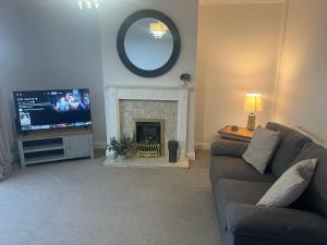 a living room with a couch and a fireplace at Duplex Flat Bedworth Town Centre in Bedworth