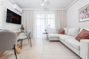ein weißes Wohnzimmer mit einem weißen Sofa und einem Tisch in der Unterkunft Comfy Aparts Plac Solny in Głogów