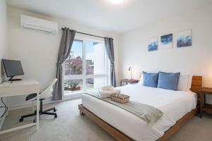 a bedroom with a bed and a desk and a window at Winslow Place BY Betterstay in Seattle