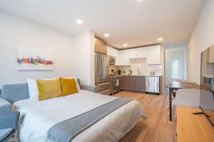 a bedroom with a large bed and a kitchen at Winslow Place BY Betterstay in Seattle