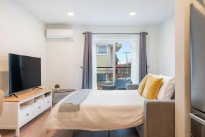 a bedroom with a large bed and a television at Winslow Place BY Betterstay in Seattle