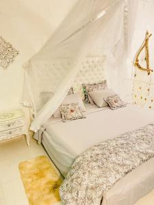 a white bedroom with a bed with a canopy at Hermosa cabaña privada cerca a Tulua con jacuzzi in La Carmine