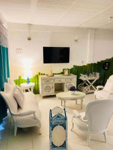 a living room with white furniture and a flat screen tv at Hermosa cabaña privada cerca a Tulua con jacuzzi in La Carmine