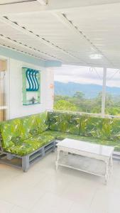 a living room with a green couch and a table at Hermosa cabaña privada cerca a Tulua con jacuzzi in La Carmine
