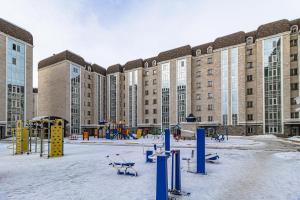 an empty playground in front of a large building at Венский Квартал-29 Apartments- Expo, Mega Silky Way in Prigorodnyy