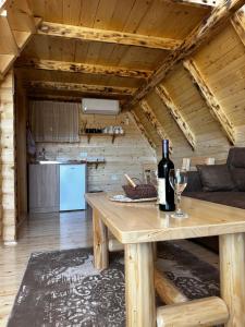 ein Holzzimmer mit einem Tisch und einer Flasche Wein in der Unterkunft Vila Durmitorska bajka in Žabljak
