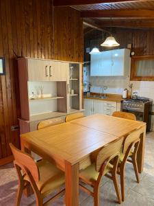 Una cocina con una mesa y sillas de madera. en Cabaña Camila, en El Bolsón 11 fotos más