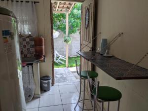 cocina con encimera y taburetes en una habitación en Kitnet Recanto do Bem-te-vi, en Jacaraípe