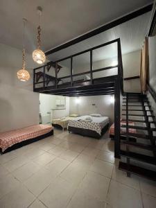 a room with two bunk beds and a staircase at Pousada Sapê in Praia do Frances