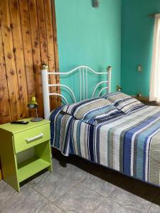 a bedroom with a bed and a nightstand with a lamp at Cabaña Camila in El Bolsón