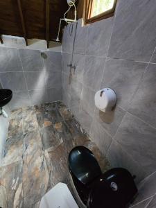 een badkamer met een toilet en een zwarte stoel bij Sierra Minca SEDE II in Arimaca