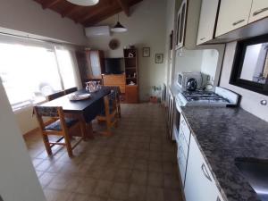 a kitchen with a table and a dining room at La Laguna - Casa familiar a 5 cuadras de la playa. in Puerto Madryn