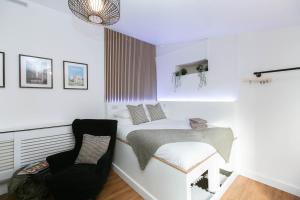 - une chambre blanche avec un lit et une chaise dans l'établissement Smart Modern Studio With Free Parking, Wifi, Close To Town, Hospital, Uni, Quiet Area, Contact For Best Prices, à Exeter