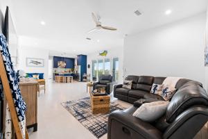 a living room with a leather couch and a table at Mermaid's Paradise ~ Pool ~ Dock ~ Games ~ Views in Marathon