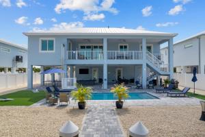 a large white house with a swimming pool at Mermaid's Paradise ~ Pool ~ Dock ~ Games ~ Views in Marathon