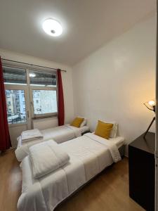 Habitación con 2 camas y ventana en Etterbeek Youth Hostel, en Bruselas