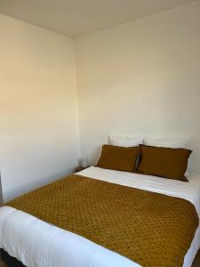 a bedroom with a large bed with brown pillows at Maison Lumière - Appart. T2 architecte intra-muros in Avignon