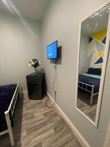 a bedroom with a mirror and a bed and a television at SUITE DREAMs CARROLL 10 in Paterson