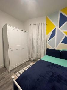 een slaapkamer met een bed en een schilderij aan de muur bij SUITE DREAMs CARROLL 10 in Paterson