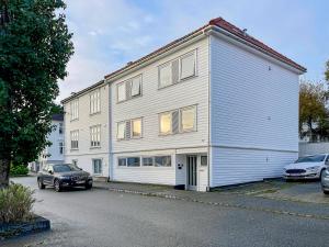 ein weißes Gebäude mit einem davor geparkt in der Unterkunft Stavanger BnB Ap5 by Berti’s in Stavanger