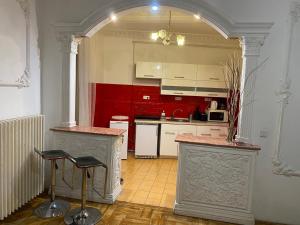 a kitchen with red cabinets and two bar stools at HearT of the city 2 bedroms, living rooms, bathrooms, with AC in Budapest