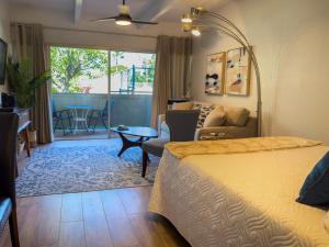 1 dormitorio con 1 cama y sala de estar en Kihei Bay Surf 130- Garden View Studio, FREE PARKING en Kihei