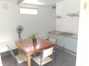 een eetkamer met een houten tafel en een keuken bij TEMAEVA LODGE in Nuku Hiva