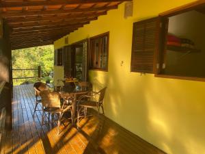 een eetkamer met een tafel en stoelen op een terras bij Chácara das Araucárias in São Francisco Xavier