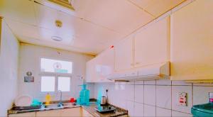 a kitchen with white cabinets and a window at Star Capsule Hostel Near Burjuman Metro Station in Dubai