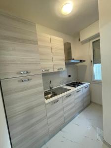 eine Küche mit Holzschränken und einem Waschbecken in der Unterkunft Casa M&N in Thiene